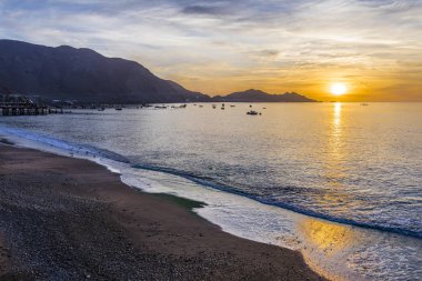 Ufuk çizgisi, Antofagasta Şili ile gitmek için çalışmakla balıkçı tekneleri ile Taltal şehir günbatımında. İnanılmaz bir pastoral plaj manzara önünde Pasifik Okyanusu Atacama Çölü, Chile 