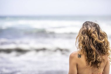 Güzel genç kız plajda ayakta. Güneşli bir gün batımı zaman sırasında bir şaşırtıcı vahşi plaj Topocalma Beach, Puertecillo, Chile