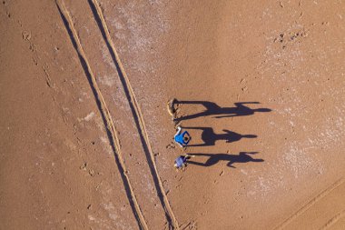 Atacama Çölünde güneş doğarken gölgeleriyle oynayan gerçek insanlar. Kuru bir manzaranın üzerindeki uzun gölgelerin dokuması inanılmaz. Elleri havada, macera başarısı iddiasında bulunuyorlar.