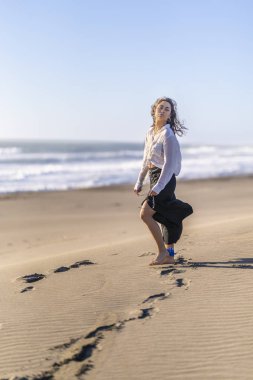 Güzel genç kız kumsalda yürüyor