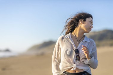 Güzel genç kız kumsalda yürüyor