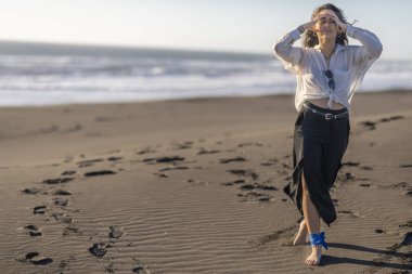 Güzel genç kız kumsalda yürüyor