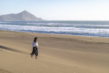 Güzel genç kız kumsalda yürüyor