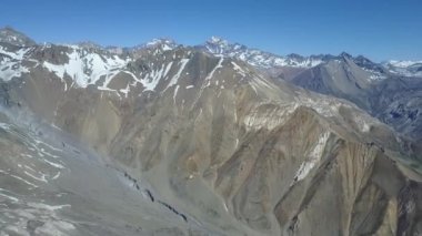Havadan çekilen görüntüler - And dağları vadileri etrafında uçmak. Bir kış güneşli bir günde Amazing sahne, uzakta San Jose Volcano ile bir göz endikatör manzara beyaz bir tabaka ile kar örtüsü Andes