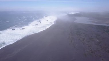 Yağmurlu bir günde sahildeki deniz fenerinin silueti 