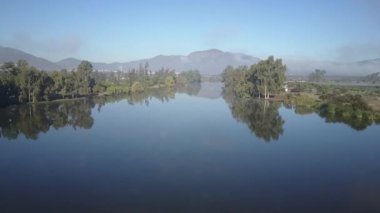 Havadan çekilen görüntüler. Kış Mevsimi'nde Caren Lagünü, ormana düşen ağaçlarla dolu inanılmaz bulut yansımaları ile sular üzerinde renkli bir aynaya yansıyan ormana yansıyan ağaçlar