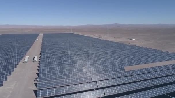 チリのアタカマ砂漠の乾燥地に沿って数百の太陽エネルギーモジュールまたはパネルの空中映像 空中ドローンの視点から砂漠の真ん中にある巨大太陽光発電所 — ストック動画