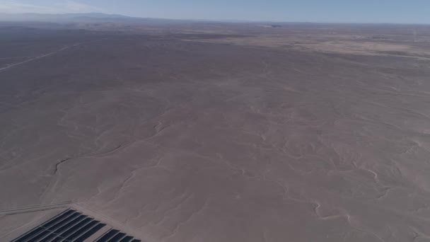 航空映像 チリのアタカマ砂漠にある太陽エネルギーファーム 何千ものモジュールの列は 太陽エネルギーPvプラントに沿って逆飛行に渡され 空中ドローンの視点から素晴らしいシーン — ストック動画