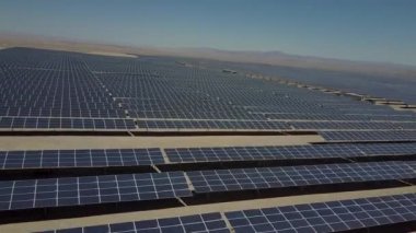 Atacama Çölü'nde kuru topraklar boyunca yüzlerce güneş enerjisi modülleri veya paneller satır hava görüntüleri, Şili. Büyük Fotovoltaik Pv Bitki görünümü bir hava drone noktasından çölün ortasında