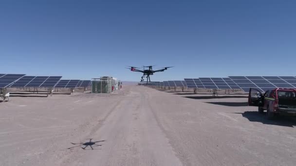 Uavのドローン映像は アタカマ砂漠のメンテナンスのために太陽エネルギー農場の空中熱検査を行うための離陸します ドローンは 地面まで太陽モジュールの間にダウンします — ストック動画
