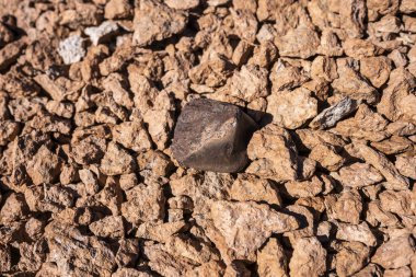 Güneşli bir günde çatlamış toprakta taş, üst manzara. 