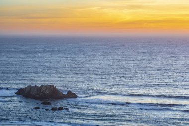 Matanzas sahilinde huzurlu bir manzara, Pasifik Okyanusu 'ndan gelen dalgalar alacakaranlık sırasında karamsar bir gökyüzü tarafından aydınlatılıyor..