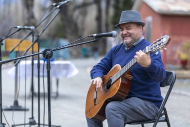Şehir: El Volcan, Santiago Ülke: And Dağları 'ndaki Cajon del Maipo vadisi içindeki El Volkan köyünde Şili 8 Ekim 2019 Madenciler Günü kutlamaları. Parti boyunca İspanyolca gitar çalan kör bir müzisyen.