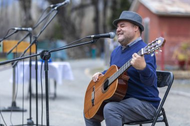 Şehir: El Volcan, Santiago Ülke: And Dağları 'ndaki Cajon del Maipo vadisi içindeki El Volkan köyünde Şili 8 Ekim 2019 Madenciler Günü kutlamaları. Parti boyunca İspanyolca gitar çalan kör bir müzisyen.