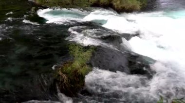 Caburgua Nehri 'nin vahşi beyaz suları Carileufu Şelalesi' ne dökülüp atlıyor. Pucon 'daki Şili yağmur ormanlarının güneyinde inanılmaz bir manzara, biraz dinlenmek için cennet manzarası.