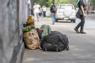 Homeless indifferent at Santiago de Chile streets during riots in the city center.  The army went out to the streets to dissolve the 