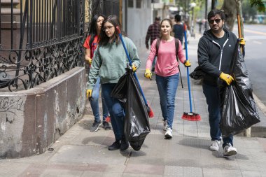 Gerçek insanlar Santiago 'daki güveç sırasında sokakları temizlemeye yardım ediyorlar. Ordu 