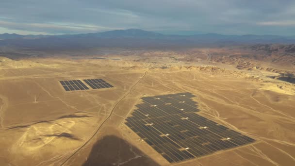 空中映像だ チリのアタカマ砂漠にある太陽光発電所 太陽光発電所に沿って何千もの太陽電池モジュールが通過野生の風景の中で空中ドローンの観点から素晴らしいシーン — ストック動画