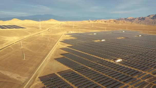 空中映像だ チリのアタカマ砂漠にある太陽光発電所 太陽光発電所に沿って何千もの太陽電池モジュールが通過野生の風景の中で空中ドローンの観点から素晴らしいシーン — ストック動画