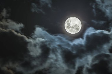 Bulutlar arasında dolunay ve cadılar bayramı arkaplanı için cennet manzarası. Uydumuz Ay 'a çarpan göktaşlarının kraterleriyle Ay' ın engebeli yüzeyi şaşırtıcıdır.
