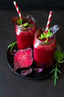 Taze pancar güler yüzlü, pancar, roka ve marul yaprakları koyu ahşap arka plan üzerinde