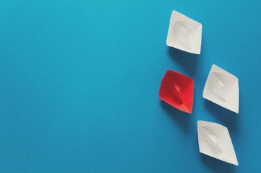 Mavi kağıt arka plan üzerinde kırmızı ve beyaz origami deniz araçları kümesi. Yaz seyahat kavramı. Üstten Görünüm. Tonda