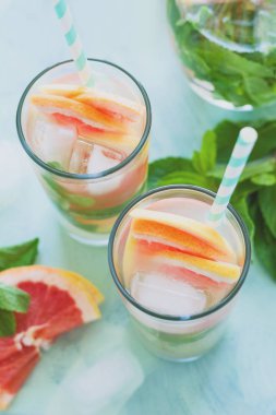 Ferahlık greyfurt nane nane kokteyli arka planını renklendirin. Sağlıklı narenciye yaz içeceği. Tonda