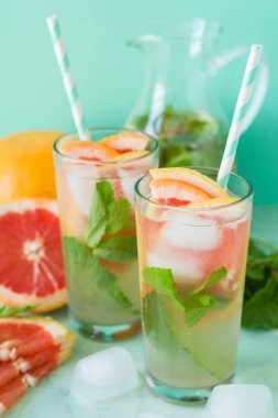 Ferahlık greyfurt nane nane kokteyli arka planını renklendirin. Sağlıklı narenciye yaz içeceği.