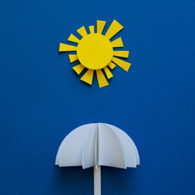 Kağıt şemsiye güneş altında. Origami. Güneş koruma ve yaz tatil kavramı