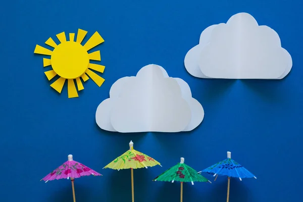 Paper umbrellas under sun. Origami. Sun protection and summer vacation concept