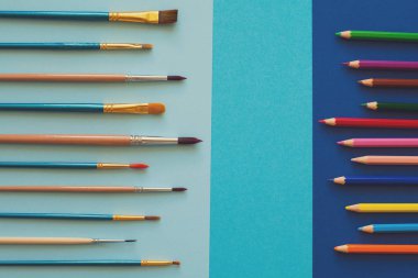 Çok renkli kalemler ve fırçalar mavi kağıt üzerinde. Okula dönüş. Uzay kopyalayın. Üstten görünüm. Düz yatıyordu. Tonda