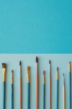 Çok renkli kalemler ve fırçalar mavi kağıt üzerinde. Okula dönüş. Uzay kopyalayın. Üstten görünüm. Düz yatıyordu. Tonda