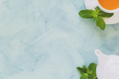 Çay kavramı. Çaydanlık ve bardak yeşil bitki çayı ile nane yaprakları ahşap zemin üzerine dekore edilmiştir. Üstten Görünüm. Uzay kopyalayın. Düz yatıyordu. Tonda