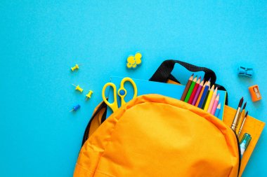 Okul konseptine geri dönelim. Okul malzemeleriyle dolu bir sırt çantası. Üst Manzara. Boşluğu kopyala