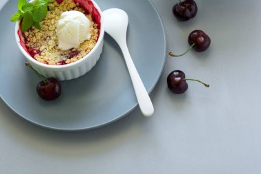 Kiraz parçalamak yulaf ezmesi ve gri ahşap masa üzerinde kase dondurma ile. Yaz sağlıklı gıda