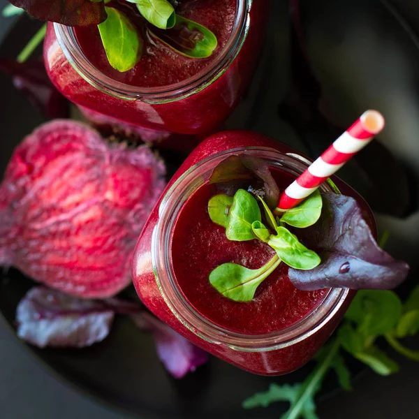 Taze pancar güler yüzlü, pancar, roka ve marul yaprakları koyu ahşap arka plan üzerinde