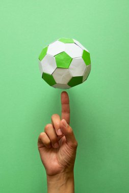 El iplik kağıt futbol topu yeşil zemin üzerine. Origami. Kağıt tekne. Futbol oyun kavramını.