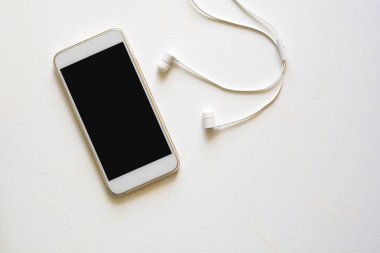 Üstten görünüm mock-up akıllı telefon ve kulaklık mavi zemin üzerine. Düz yatıyordu. Kopya için alan