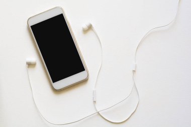 Üstten görünüm mock-up akıllı telefon ve kulaklık mavi zemin üzerine. Düz yatıyordu. Kopya için alan