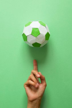 El iplik kağıt futbol topu yeşil zemin üzerine. Origami. Kağıt tekne. Futbol oyun kavramını.