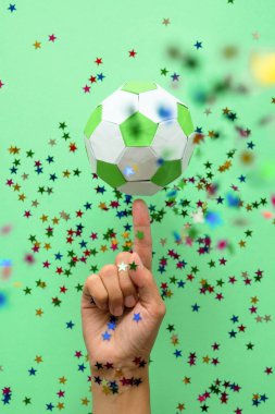 El iplik kağıt futbol topu yeşil zemin üzerine. Origami. Kağıt tekne. Futbol oyun kavramını.