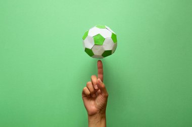 El iplik kağıt futbol topu yeşil zemin üzerine. Origami. Kağıt tekne. Futbol oyun kavramını.