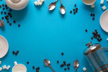 Çeşitli kahve aksesuarları yapma: Fransızca kahve basın, bardaklar, tabaklar, kahve çekirdekleri, kaşık ve şeker mavi Kağıt arka plan üzerinde. Günaydın kavramı. Kopya için alan. Üstten görünüm. Düz yatıyordu