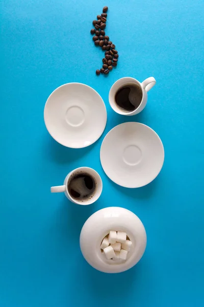 Tassen Mit Espresso Spritzer Untertassen Teelöffel Und Kaffeebohnen Auf Blauem — Stockfoto