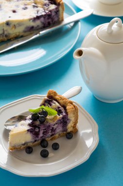 Çay saati. Mavi Kağıt arka plan üzerinde ricotta peynirli ev yapımı yaban mersinli cheesecake