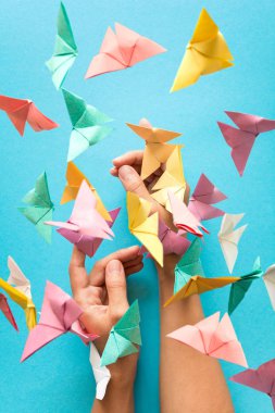 Ruh sağlığı kavramı. Renkli kağıt kadının elleri üzerinde oturan ve uçan kelebekler. Uyum duygu. Origami. Tarzı kağıt kesme.