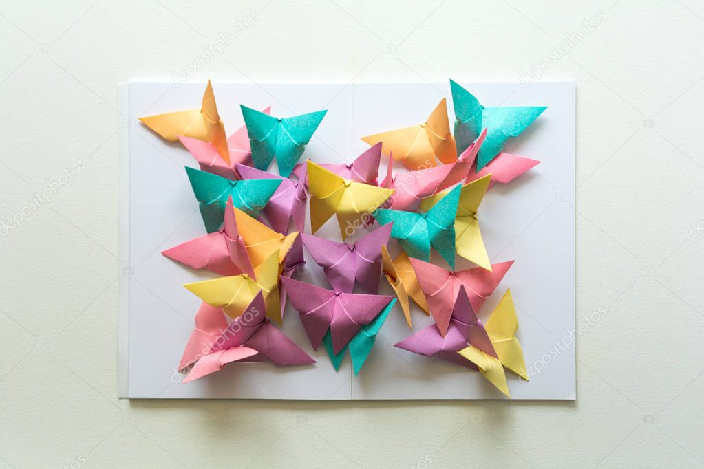 Mental health concept. Colorful paper butterflies sitting on book in shape of butterfly. Harmony emotion. Origami. Paper cut style.