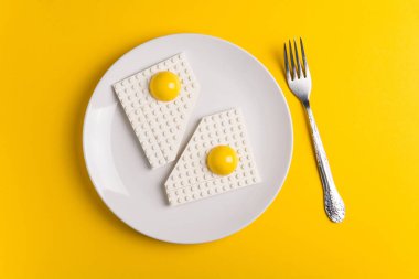 Beyaz plaka sarı Kağıt arka plan üzerinde üstten görünüm çocuk Tasarımcısı kızarmış yumurta ile. İyi