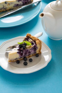 Çay saati. Mavi Kağıt arka plan üzerinde ricotta peynirli ev yapımı yaban mersinli cheesecake