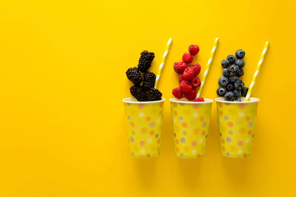 Pappbecher Mit Frischen Himbeeren Blaubeeren Und Brombeeren Liegen Auf Gelbem — Stockfoto